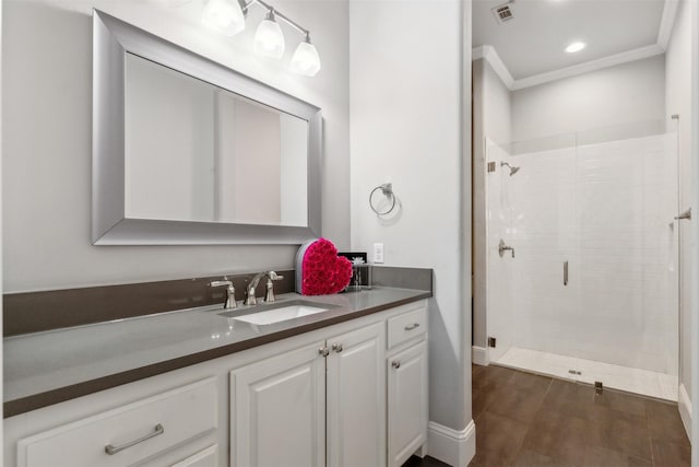 bathroom featuring walk in shower, crown molding, and vanity