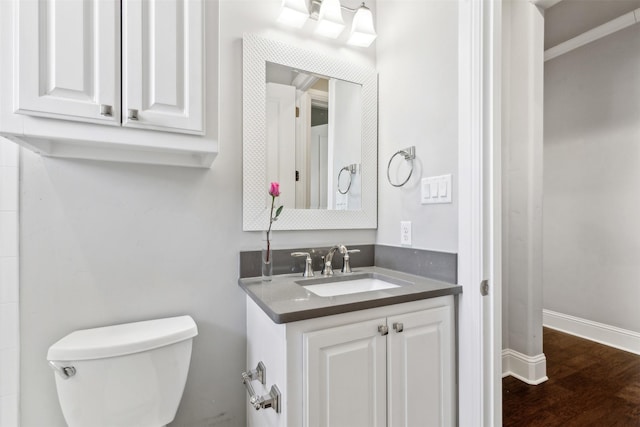 bathroom with toilet, vanity, and hardwood / wood-style flooring