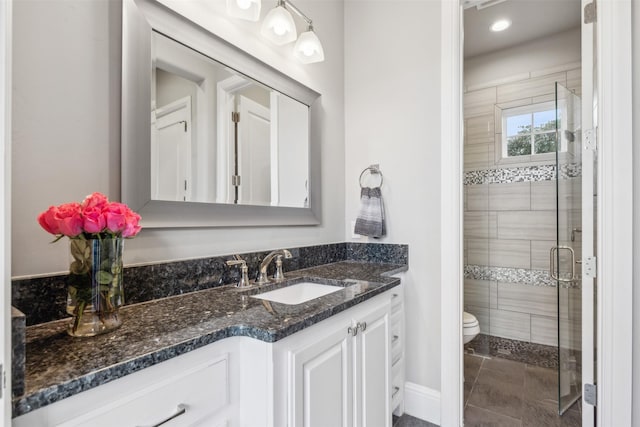 bathroom featuring toilet, tile patterned flooring, an enclosed shower, and vanity