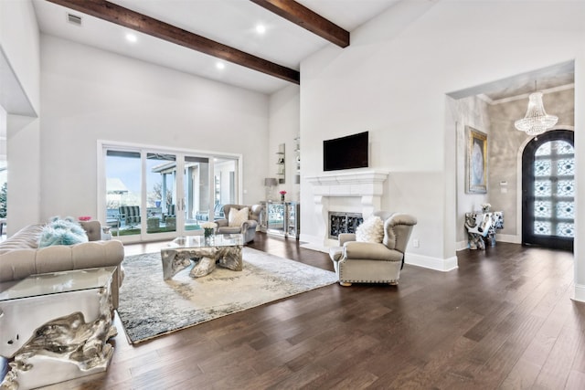 living room with a high ceiling, beam ceiling, a notable chandelier, and dark hardwood / wood-style floors