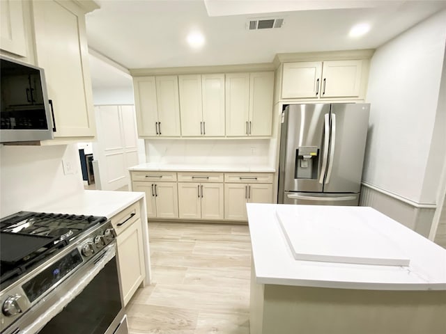 kitchen with appliances with stainless steel finishes and cream cabinetry