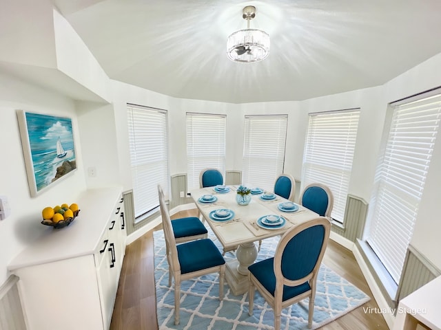 dining space with light hardwood / wood-style floors and a notable chandelier