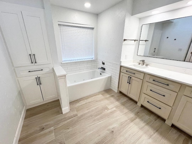 bathroom featuring a tub to relax in, vanity, and wood-type flooring