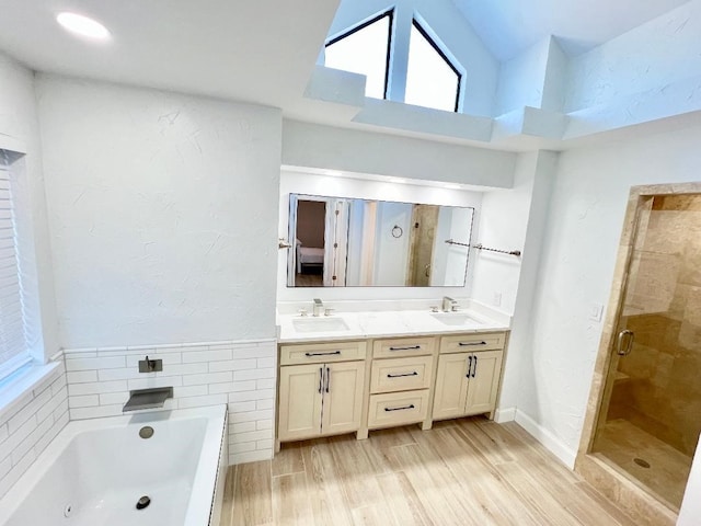 bathroom featuring a high ceiling, separate shower and tub, vanity, and hardwood / wood-style flooring