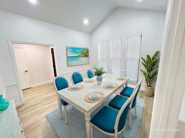 dining area featuring vaulted ceiling and light hardwood / wood-style flooring