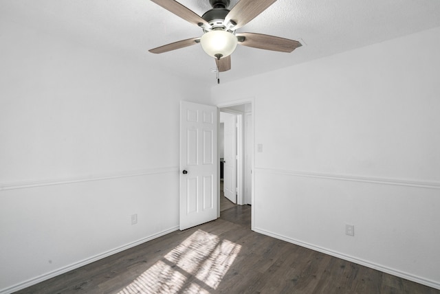 unfurnished room featuring ceiling fan and dark wood-type flooring