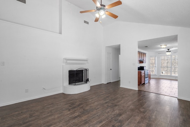 unfurnished living room with a textured ceiling, a fireplace, vaulted ceiling, ceiling fan, and dark wood-type flooring