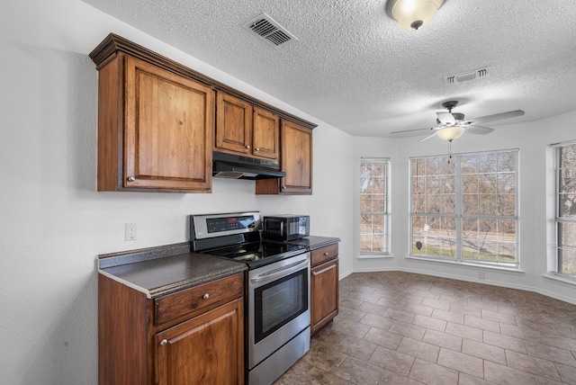 kitchen featuring a textured ceiling, ceiling fan, stainless steel electric range, and dark tile patterned floors