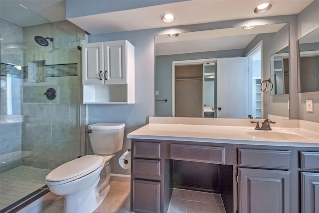 bathroom featuring tiled shower, tile patterned flooring, vanity, and toilet