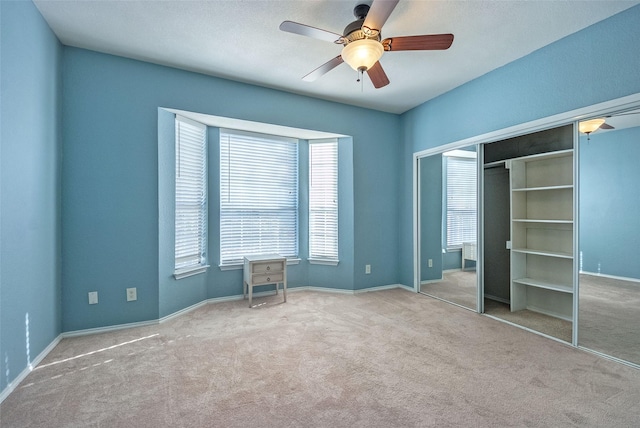 unfurnished bedroom featuring ceiling fan, a closet, and carpet flooring