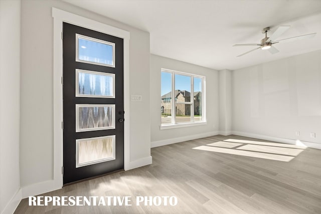 foyer entrance with ceiling fan and light hardwood / wood-style floors