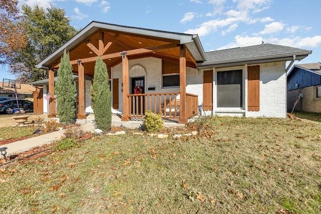 back of property with a yard and covered porch