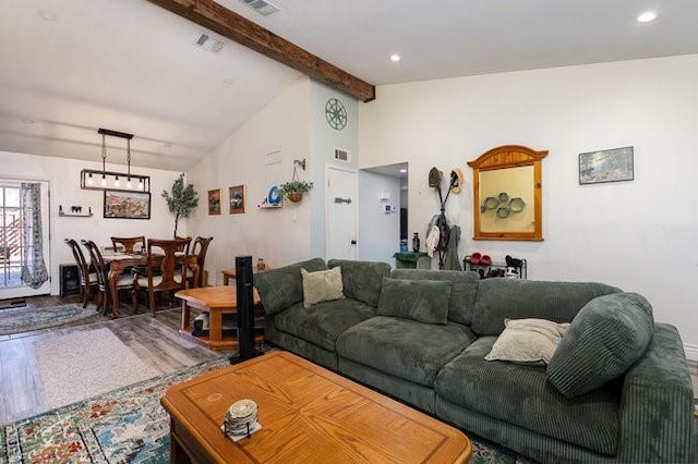 living room with wood-type flooring and vaulted ceiling with beams