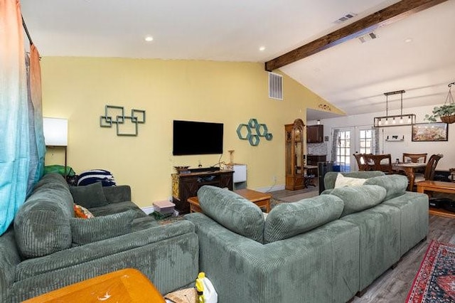 living room with hardwood / wood-style flooring and vaulted ceiling with beams