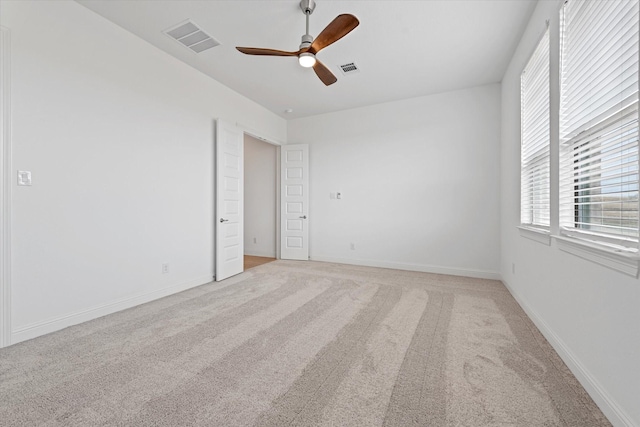 carpeted spare room featuring ceiling fan