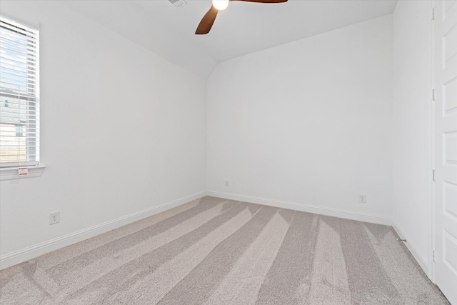 carpeted empty room featuring ceiling fan and vaulted ceiling