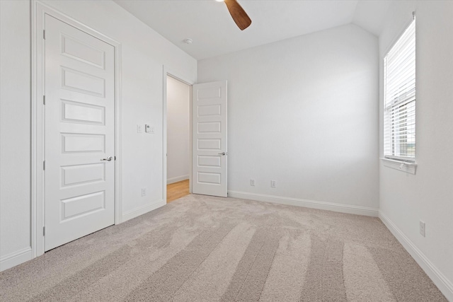 unfurnished bedroom with ceiling fan, light colored carpet, and lofted ceiling