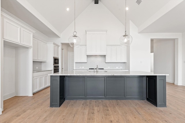 kitchen with white cabinetry, tasteful backsplash, hanging light fixtures, and a spacious island