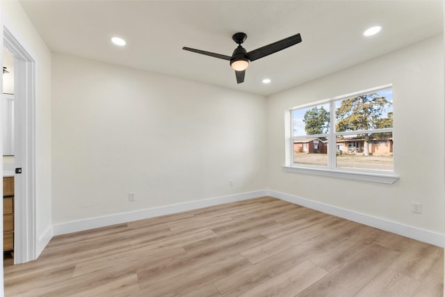 empty room with ceiling fan and light hardwood / wood-style floors