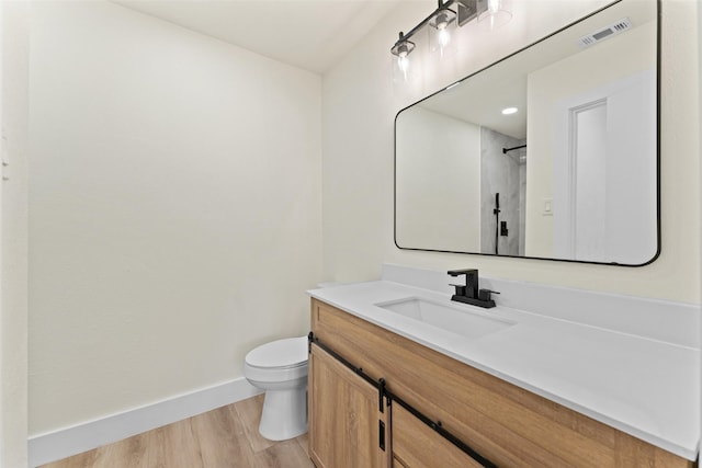 bathroom featuring toilet, vanity, and hardwood / wood-style floors