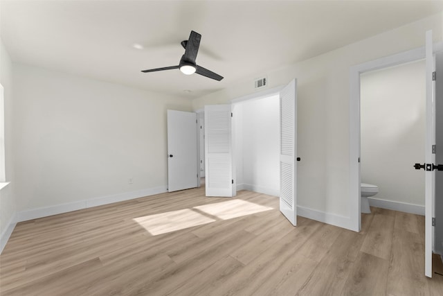 unfurnished bedroom with ensuite bath, a closet, ceiling fan, and light hardwood / wood-style floors