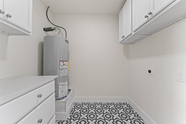 washroom with electric water heater, light tile patterned floors, cabinets, and hookup for an electric dryer