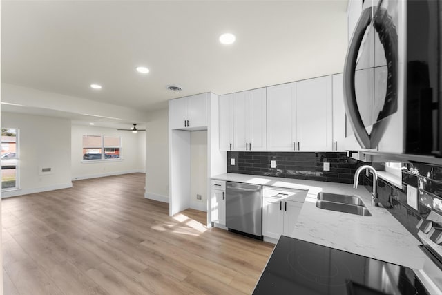 kitchen with white cabinets, stainless steel dishwasher, ceiling fan, and sink