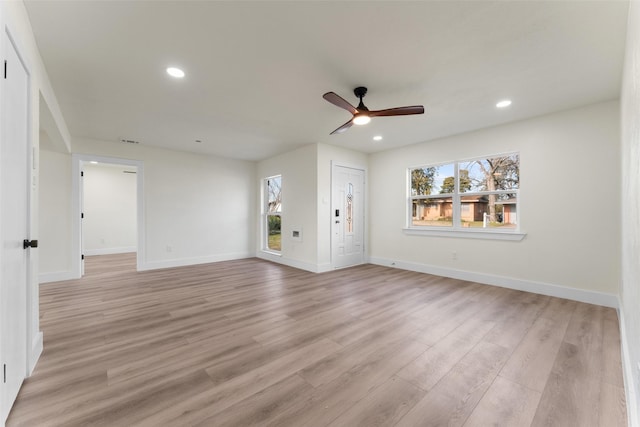 unfurnished living room featuring ceiling fan and light wood-type flooring