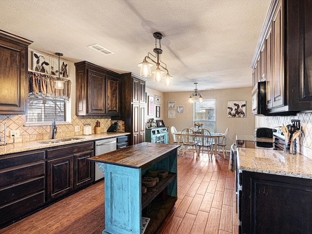 kitchen featuring butcher block counters, dark brown cabinetry, and sink