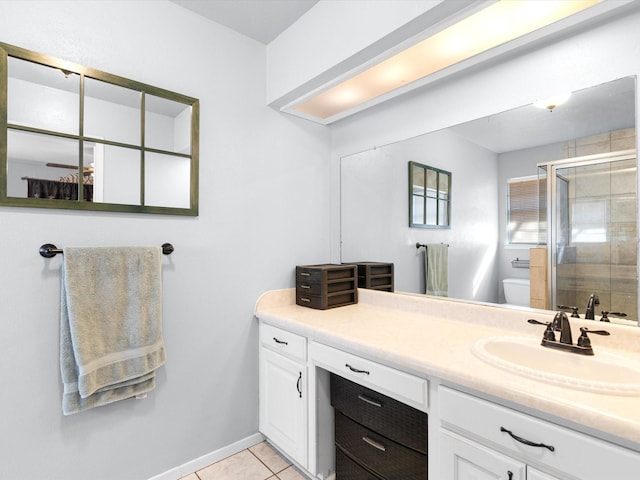 bathroom with a shower with door, tile patterned flooring, vanity, and toilet