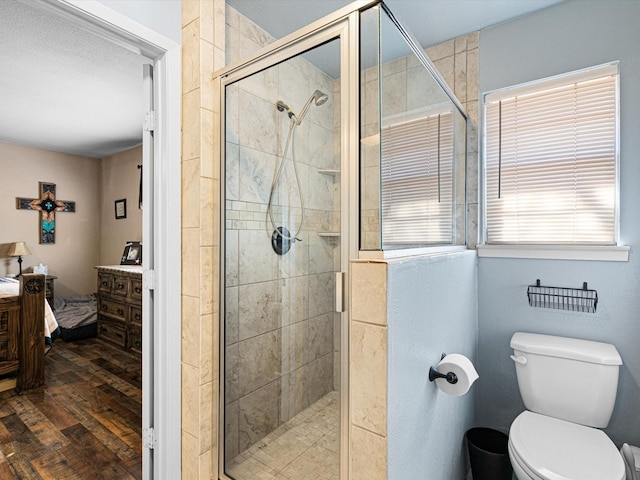 bathroom featuring toilet, wood-type flooring, and walk in shower