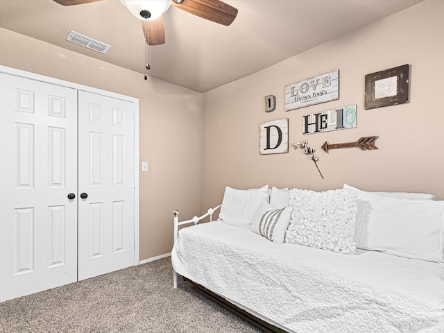 carpeted bedroom with ceiling fan and a closet