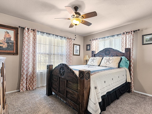 carpeted bedroom featuring ceiling fan, multiple windows, and a textured ceiling