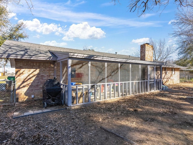 rear view of property featuring a sunroom