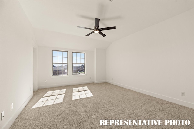 carpeted empty room with ceiling fan and vaulted ceiling