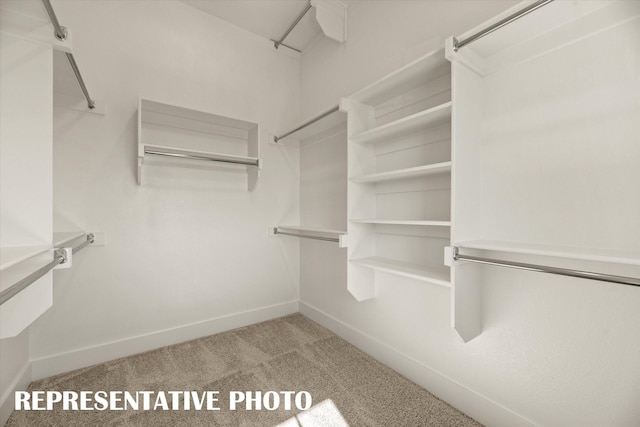 walk in closet featuring light carpet