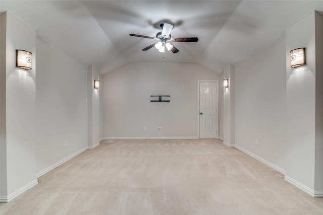 interior space with ceiling fan, vaulted ceiling, and light carpet