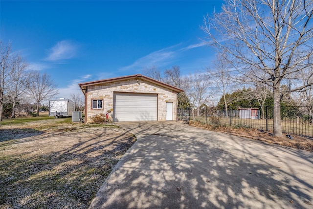 view of side of home featuring central AC unit, a garage, and an outdoor structure