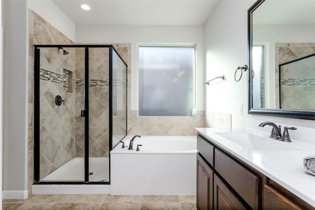 bathroom featuring shower with separate bathtub and vanity