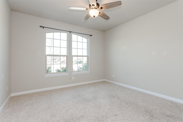 carpeted spare room featuring ceiling fan