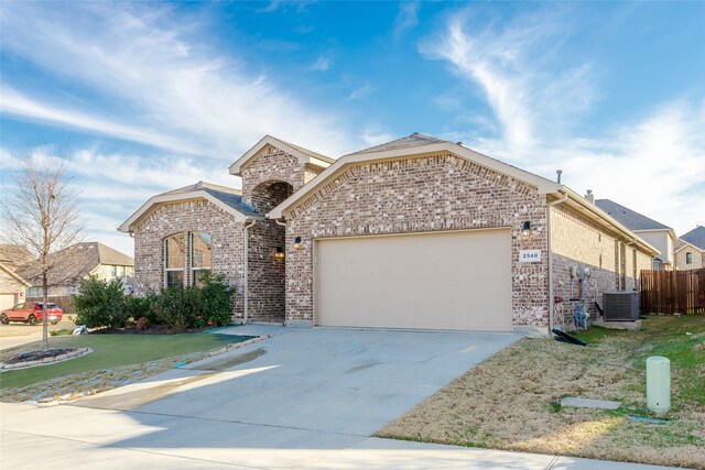 view of front of property featuring central AC, a front yard, and a garage