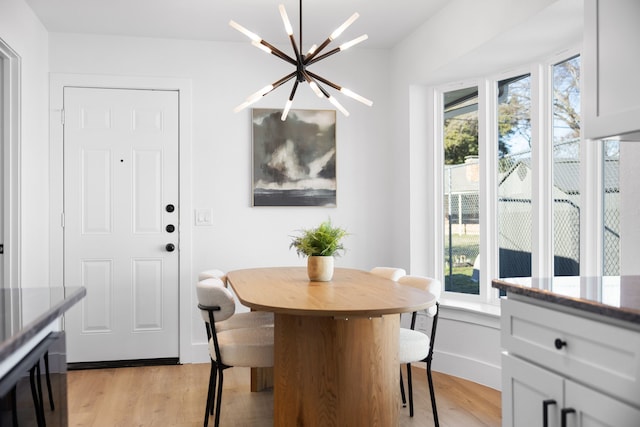 dining space featuring light wood-type flooring, a chandelier, and wine cooler