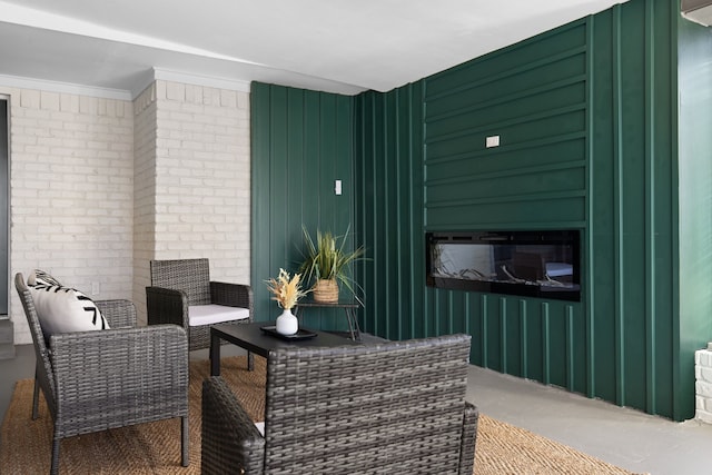 sitting room with brick wall and crown molding