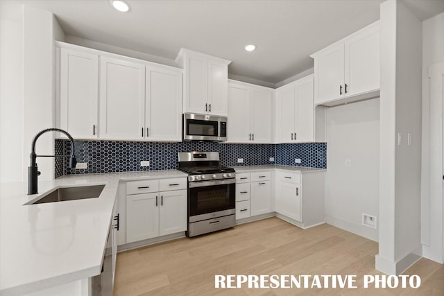 kitchen with white cabinets, appliances with stainless steel finishes, and sink