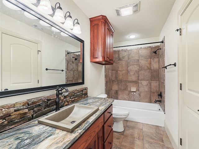 full bathroom featuring toilet, vanity, and tiled shower / bath combo