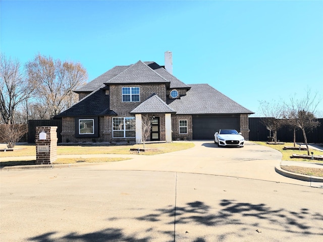 view of front of property featuring brick siding, roof with shingles, a chimney, an attached garage, and driveway