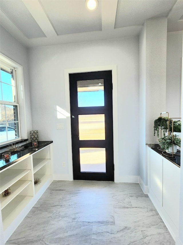 foyer with marble finish floor and baseboards