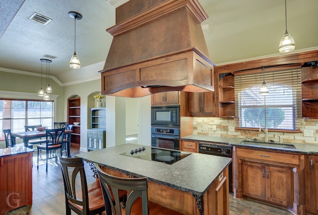 kitchen featuring sink, vaulted ceiling, custom range hood, a kitchen island, and black appliances