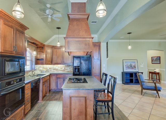 kitchen with sink, a center island, ornamental molding, pendant lighting, and black appliances