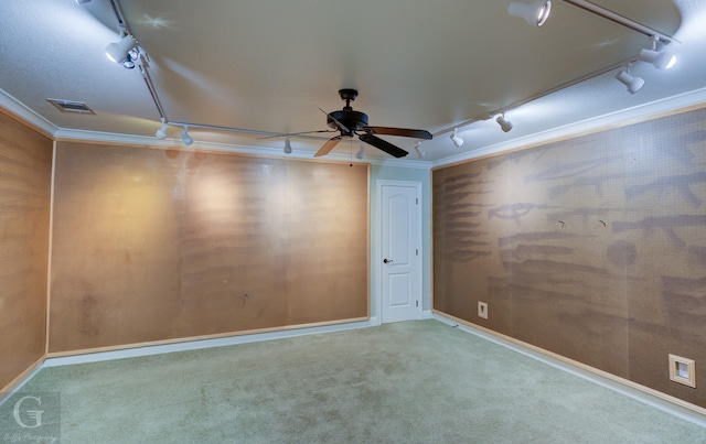 carpeted spare room with ceiling fan, ornamental molding, and rail lighting